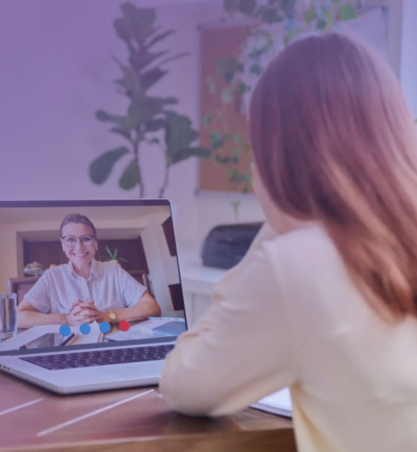 Woman video chatting with a doctor on a laptop.