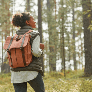 Woman hiking in the forest with a backpack.