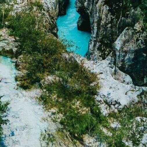 Turquoise river flowing through rocky green canyon